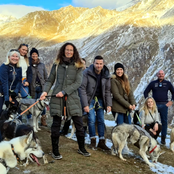 Team-Husky-Trekking-Event in Saas-Fee - Gruppe mit Huskys vor beeindruckender Bergkulisse in den Walliser Alpen