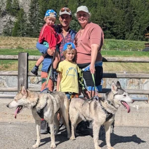 Familienfoto mit zwei Huskys – gemeinsamer Abschluss eines Husky-Trekkings in Saas-Balen, voller Freude, Natur und Verbundenheit